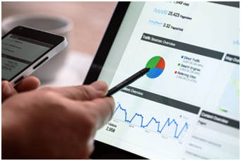 Person analyzing website traffic data on a tablet, showing graphs and pie charts, representing SEO performance and digital marketing analysis.